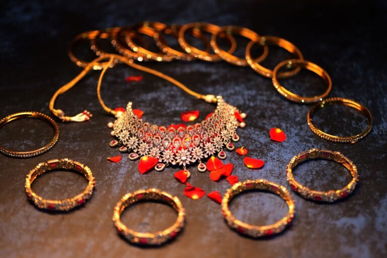 Intricate gold jewelry set with red petals for celebrations and weddings.